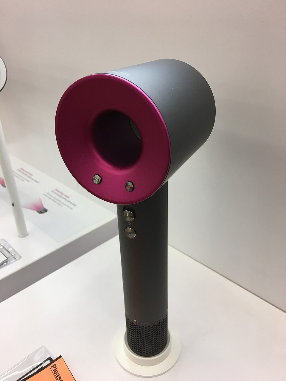 a dyson hair dryer from the same family as the airwrap, standing on a wood floor