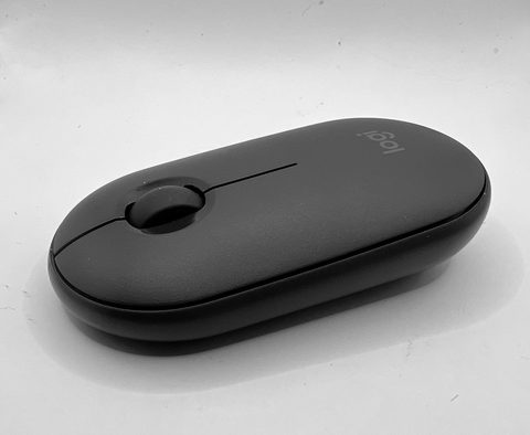 a logitech pebble mouse sitting on a white desk