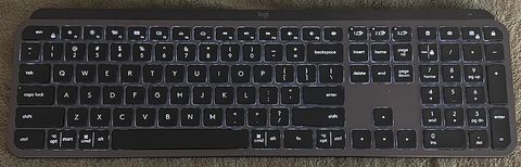 a logitech mx keys wireless keyboard, the mini's full size sibling, on a desk
