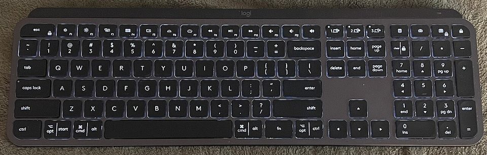 a logitech mx keys wireless keyboard, the mini's full size sibling, on a desk