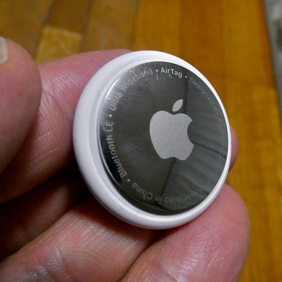 A white Apple AirTag disc photographed up close