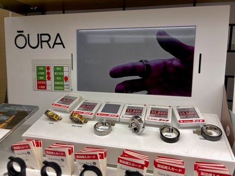 A small titanium Oura smart ring photographed on a plain surface