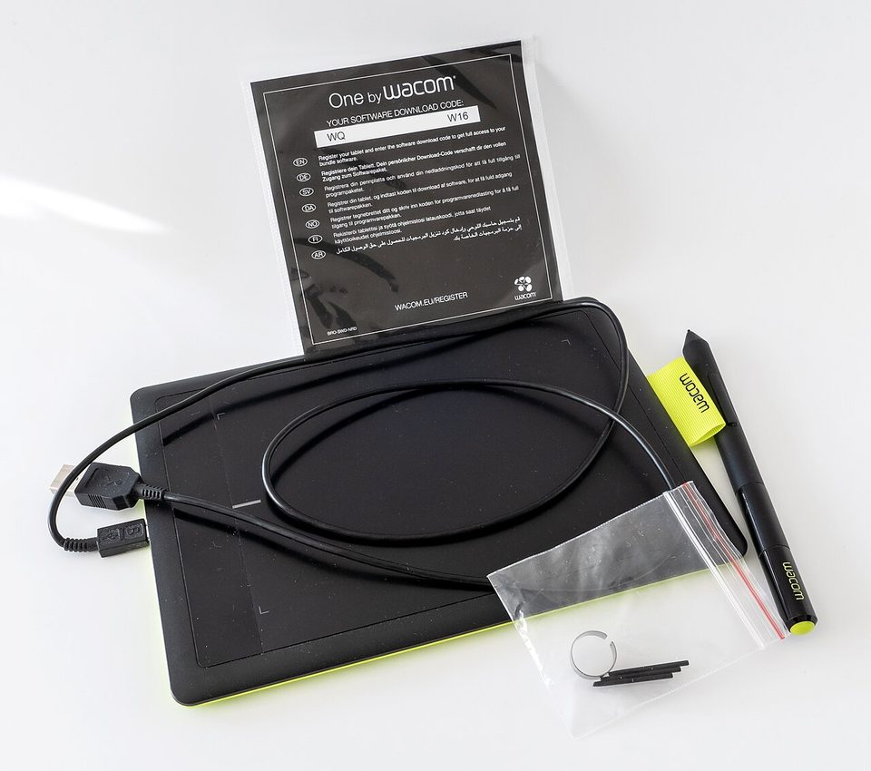 A Wacom One pen tablet with its stylus resting on the pen holder