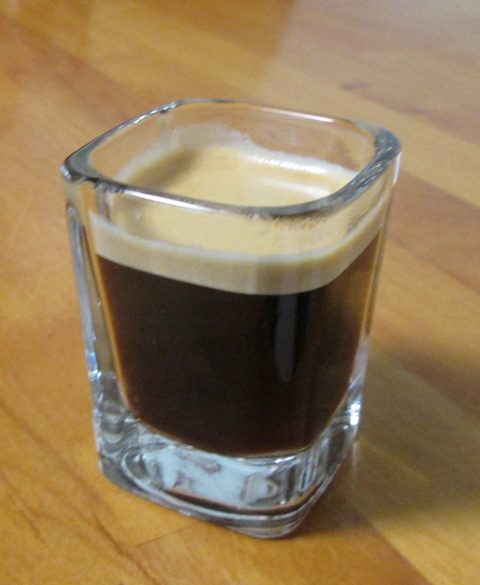 A cup of Nespresso coffee topped with a thick layer of golden crema