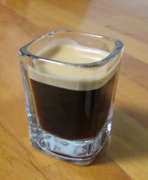 A cup of Nespresso coffee topped with a thick layer of golden crema