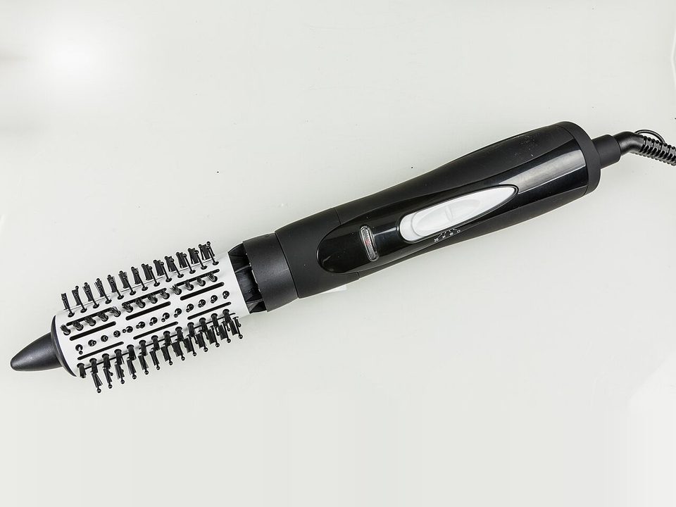 a black hot air brush with a round bristle head on a white backdrop, a simpler cousin of the flexstyle's brush attachment, not the flexstyle itself