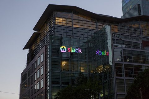 Slack headquarters at 500 Howard Street in San Francisco at dusk, with the lit Slack logo on the glass facade
