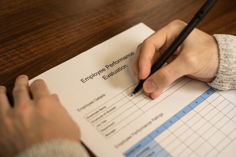 A printed employee performance evaluation form with rating boxes, the paper ancestor of the employee record