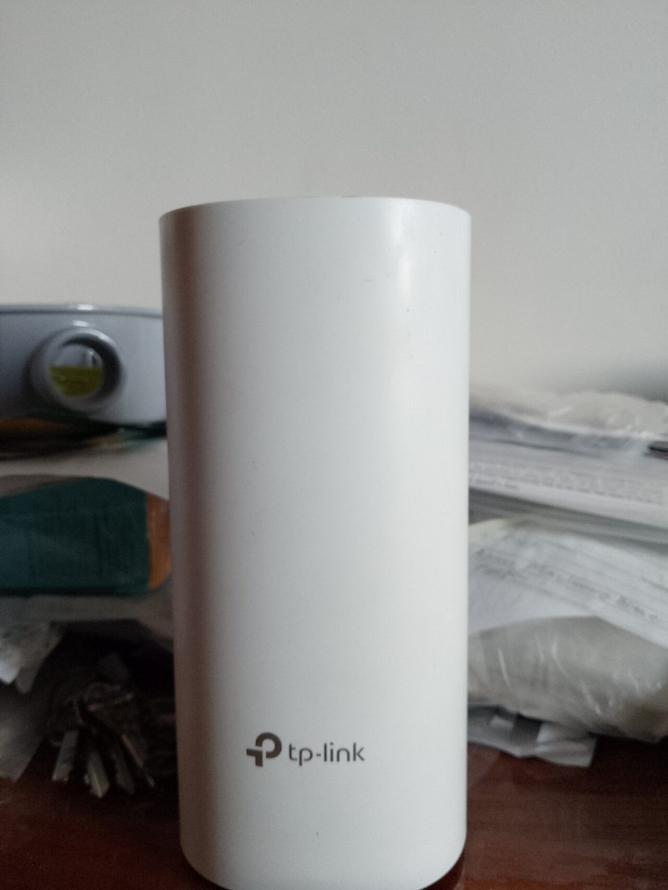 A white TP-Link Deco mesh node standing on a desk