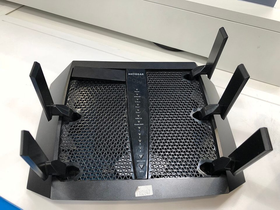 A black Nighthawk router with six external antennas seen from above