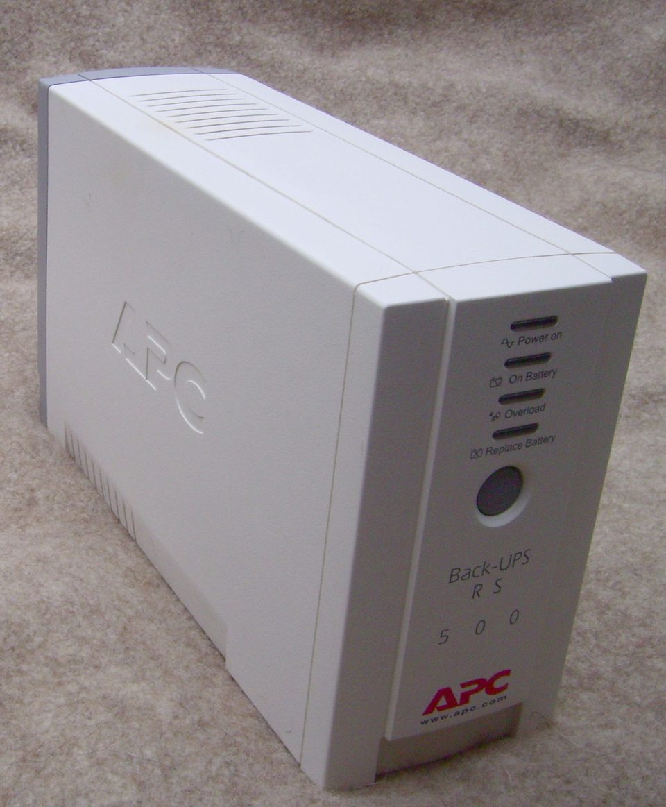 An APC Back-UPS desktop unit showing its status lights, including the replace battery indicator
