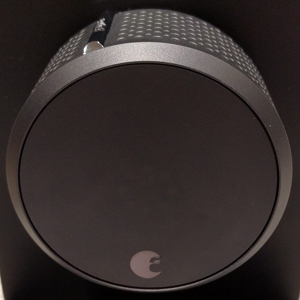 An August smart lock, the silver rounded disc that fits over the inside of a deadbolt