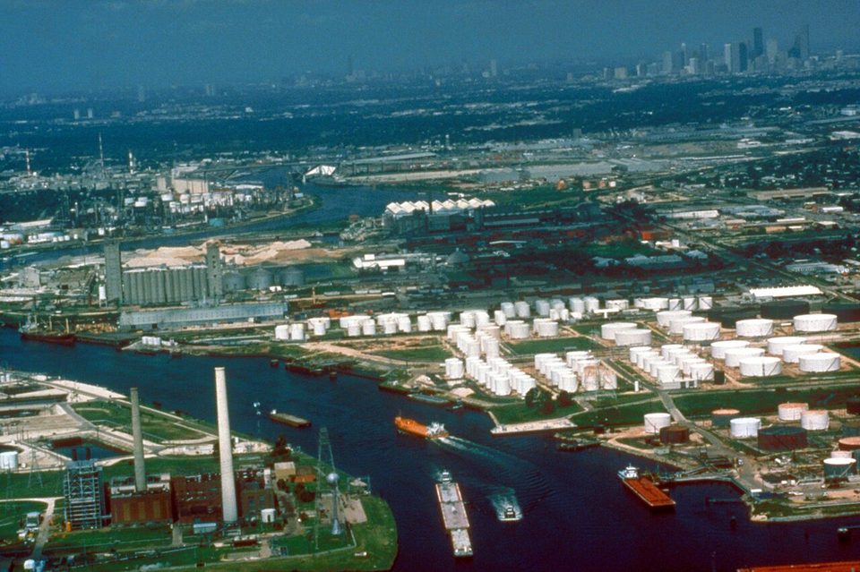 Aerial view of the Houston Ship Channel at Galena, tankers and barges moored along the banks with the refinery skyline behind