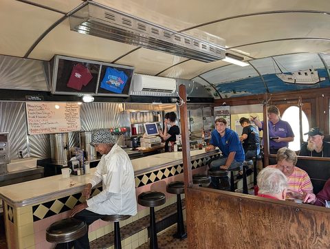 Interior of a small diner with booths and counter stools