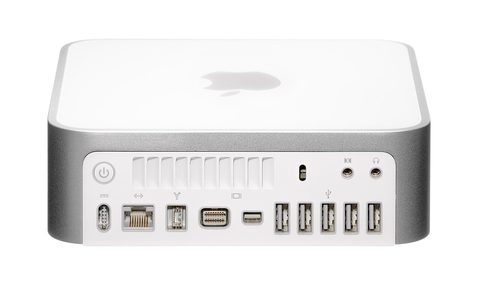 A Mac mini sitting on a desk beside a monitor