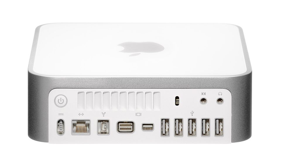 A Mac mini sitting on a desk beside a monitor