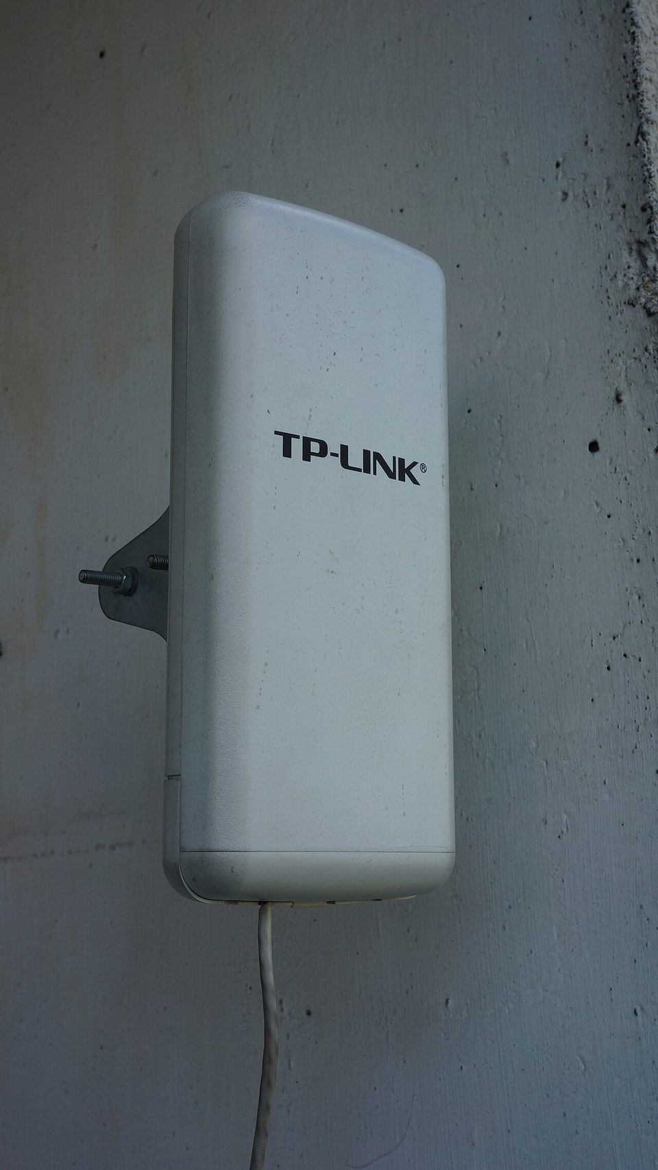 A TP-Link Omada management dashboard on a tablet next to Omada network hardware