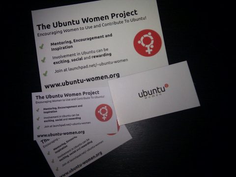 A Vistaprint order of printed business cards and a postcard fanned out on a dark table