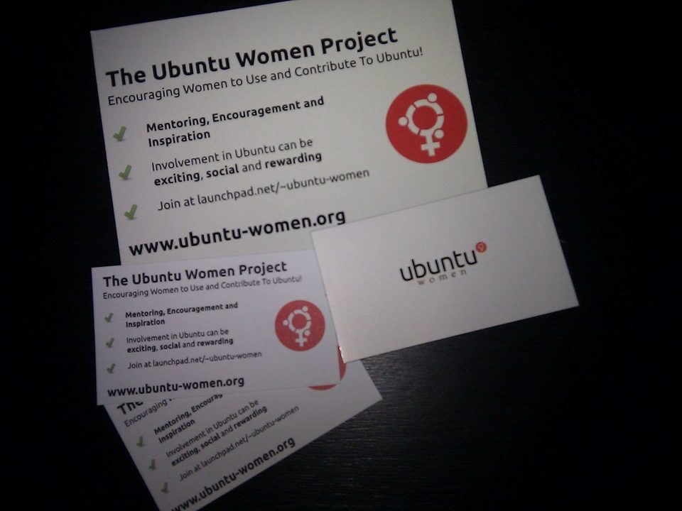 A Vistaprint order of printed business cards and a postcard fanned out on a dark table