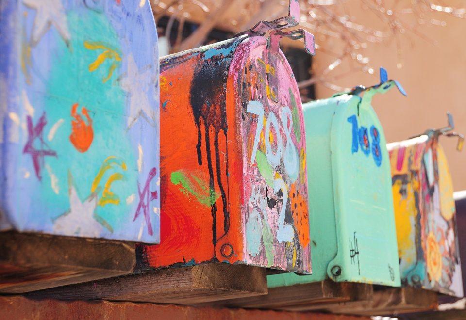 A row of rural mailboxes on posts along a roadside in Santa Fe, New Mexico