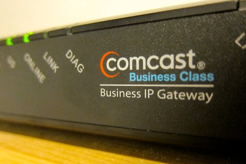 Close-up of a Comcast Business Class IP Gateway with its green status lights on